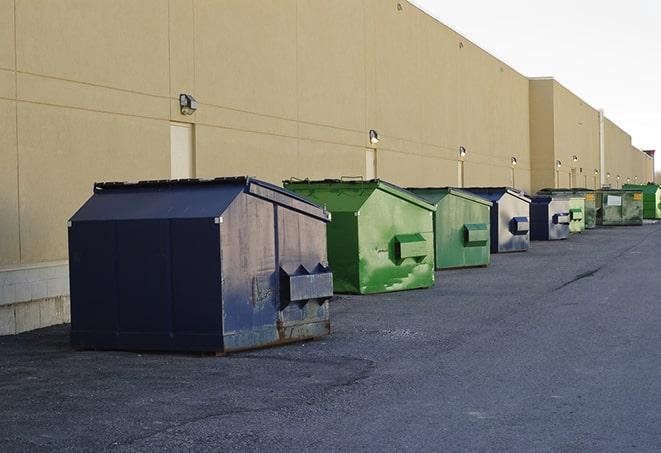 a fleet of red and blue construction dumpsters available for use in Ankeny